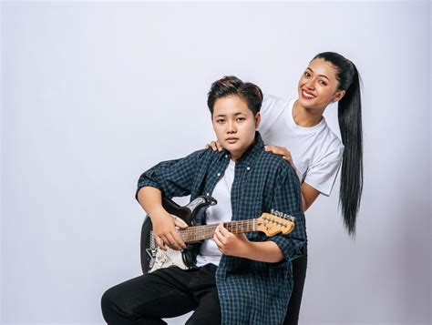 Two young women sat on a chair and played guitar. 4837918 Stock Photo ...