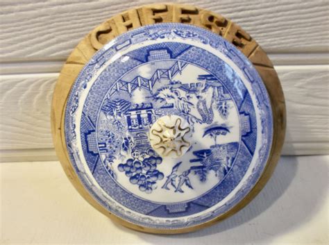 a blue and white plate sitting on top of a wooden stand next to a wall