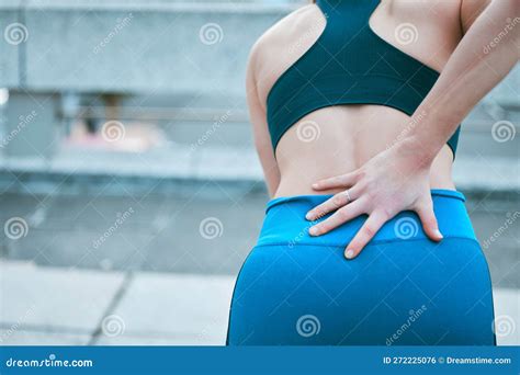 Closeup of One Caucasian Woman Holding Her Sore Lower Back while Exercising Outdoors. Female ...