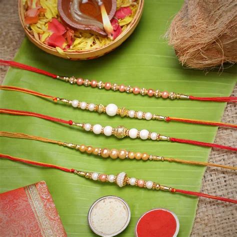 eCraftIndia Set of 5 White & Golden Pearls Rakhis with Roli Chawal Pac