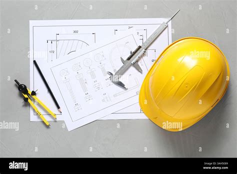 Different engineering drawings, hard hat, pencil, divider and vernier ...