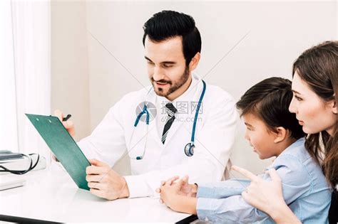 医生在医院的医生桌上与小男孩和妈核对信息医高清图片下载-正版图片505387979-摄图网