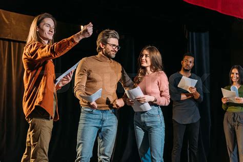multicultural actors and actresses rehearsing on stage in theatre ...