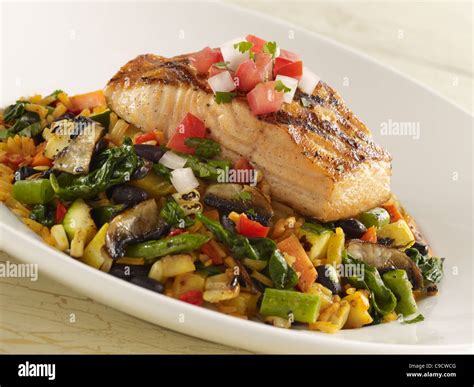 Close-up on salmon fillet with fruit salsa, over rice.
