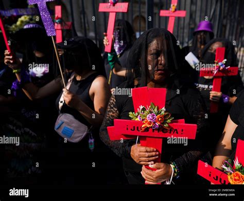 Demonstrators in black veils holds crosses with a Spanish word "Justice ...