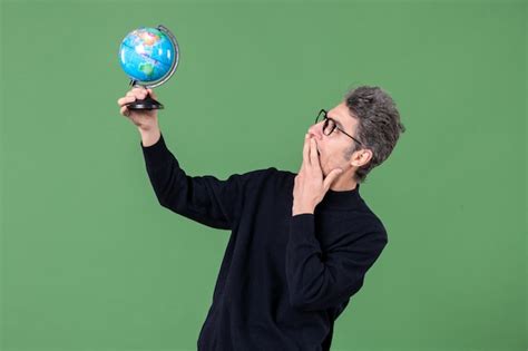 Retrato de homem gênio segurando globo terra estúdio tiro fundo verde ...
