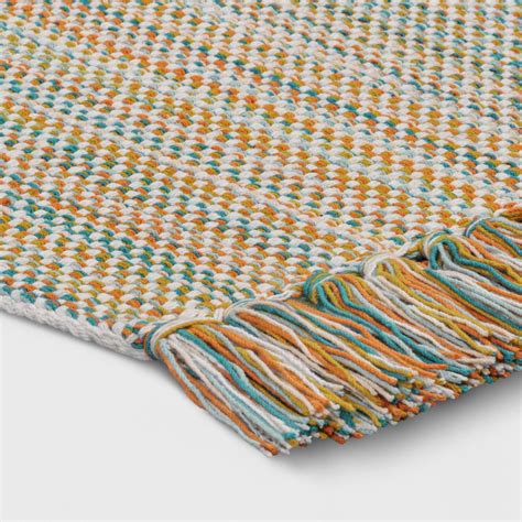 a multicolored rug with fringes on the top and bottom, sitting on a ...