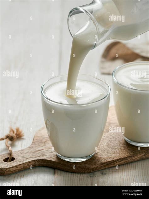 Pouring kefir, buttermilk or yogurt with probiotics. Yogurt flowing ...