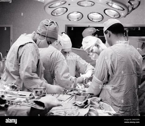 1960s DOCTORS SURGEONS NURSES IN OR STERILE CAPPED MASKED AND GOWNED ...