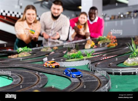 Toy remote control racing cars on the track and enthusiastic players Stock Photo - Alamy