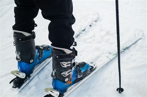 Closeup of the leg of a skier athlete in ski boots goes up on skis ...