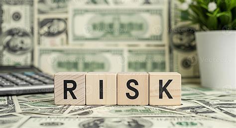 Wooden blocks spelling RISK on a bed of US currency with a calculator ...