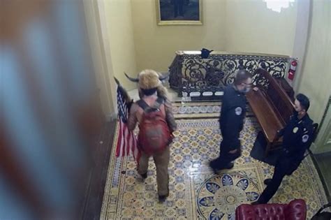Jan. 6 footage shows cops bringing QAnon Shaman to Senate floor