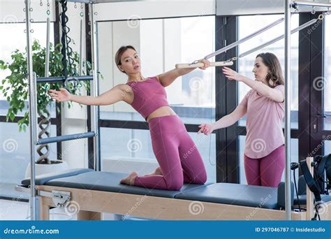 Asian Woman Doing Pilates with Trainer on Cadillac Reformer. Stock ...