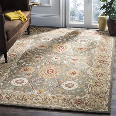 A traditional woolen hand-tufted carpet with a floral pattern ...
