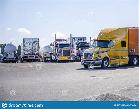 在停车场上行驶的大钻黄半卡车经过排列的其余卡车 库存照片. 图片 包括有 货车使用费, 公司, 运费, 行业 - 167315966