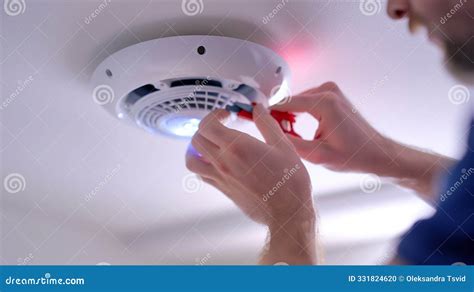 Man Changing Batteries in Smoke Detectors, Ensuring Proper ...