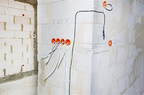 Orange round junction box mounted in the white wall with protruding ...
