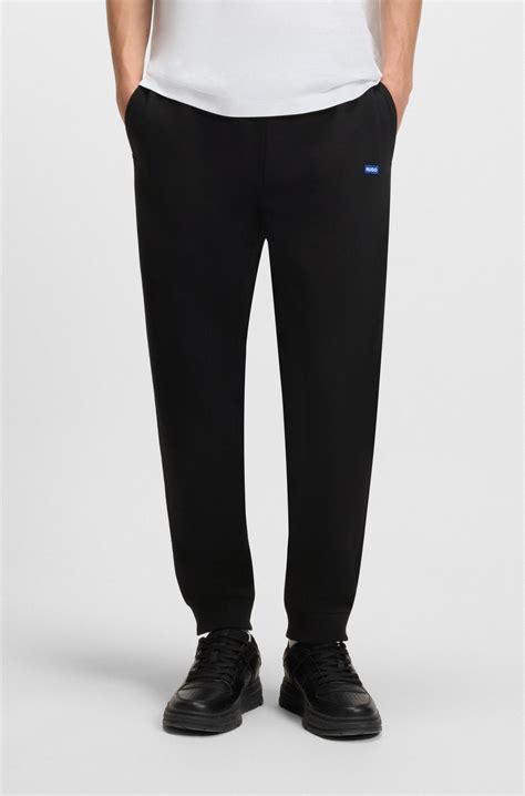 HUGO - Cotton-terry tracksuit bottoms with blue logo patch