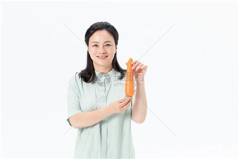 中年女性手拿胡萝卜高清图片下载-正版图片501378616-摄图网