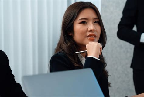 Focus portrait of asian female manger with blurred colleague figures in ...
