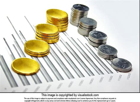 Stacks-of golden and steel coins on-business graph paper Business ...