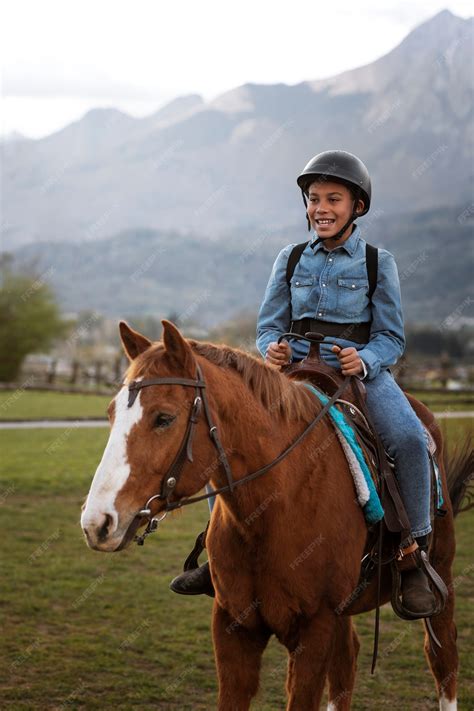 Niño aprendiendo a montar a caballo | Foto Gratis