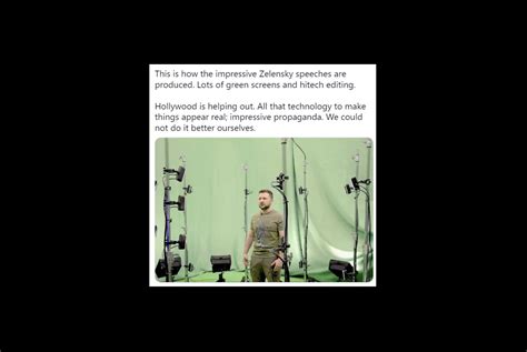 Zelensky wearing a green shirt speaks in a dimly-lit room. An out-of-focus Christmas tree is in the