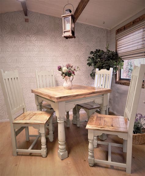 a wooden table and chairs in a room with white walls, wood flooring and ...