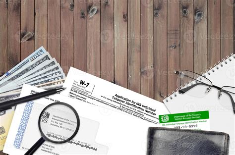 IRS form W-7 Application for IRS individual taxpayer identification number lies on flat lay ...