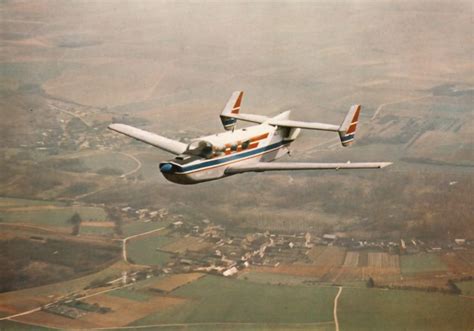 an airplane is flying in the sky over farmlands and fields with houses ...