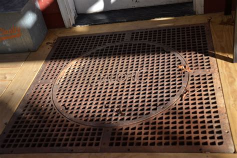 a metal grate sitting on top of a wooden floor next to a white door