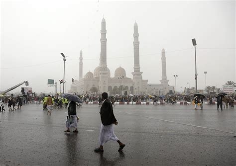 People walk through the rain in Sana'a, Yemen, in October 2023. Photo: Mohammed Hamoud/Getty Images.