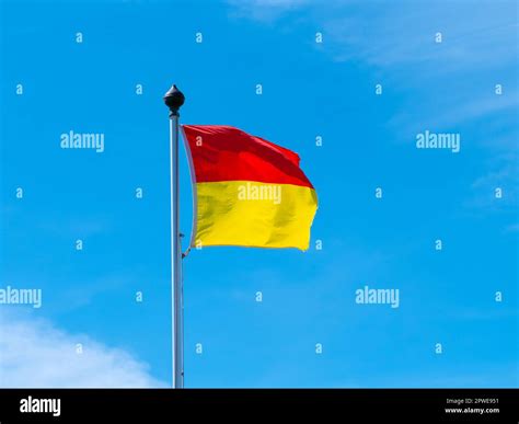 A red and yellow flag allowing swimming on the beach. One flag on a ...