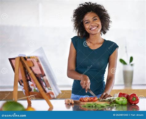 Happiest when Im Cooking. a Young Woman Cooking from a Recipe Book ...
