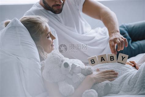 男子在家中用泰迪熊的怀孕妻子肚上放置木砖块和婴儿字高清图片下载-正版图片503019917-摄图网