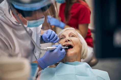 Dentist carrying out dental procedure on male patient, close-up