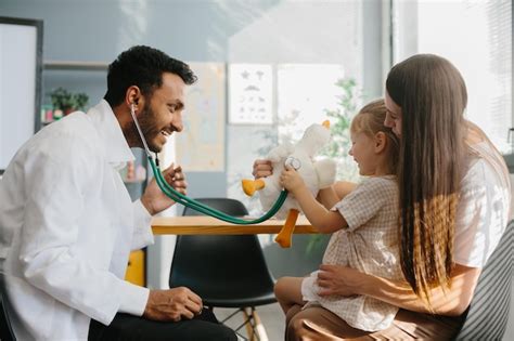 Happy little girl mother and family doctor playing fun game with toy ...