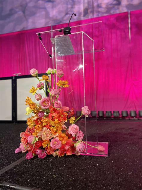 Dress up an acrylic podium with bright florals to captivate your guests ...