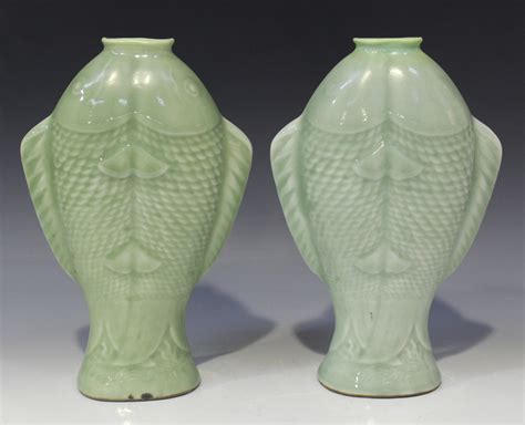 A pair of Chinese celadon glazed twin fish moulded porcelain vases ...