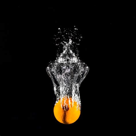 Orange plunging into the water | Free Photo