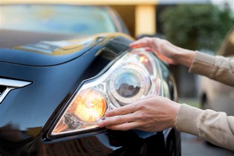 Hand holding headlight of dark car | Premium Photo