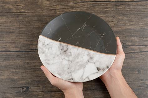Top view of man hands holding an empty beautiful plate on a wooden ...
