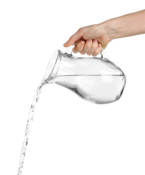 Pouring water from glass pitcher isolated on white | Premium Photo