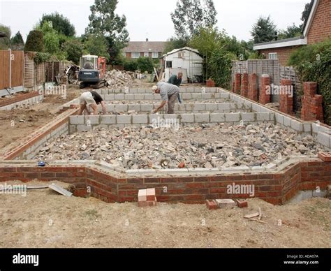 Labourers hand picking & levelling hardcore rubble around foundation ...