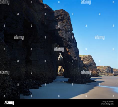 Natural arch at As Catedrais beach durng low tide. Atlantic Ocean coast ...