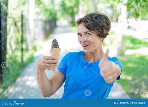 Charming Caucasian Woman with a Short Haircut Smiles Holds an Ice Cream ...