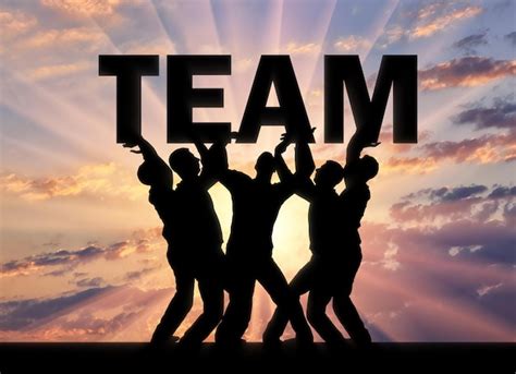 Silhouette of a group of men who hold the word team above themselves ...