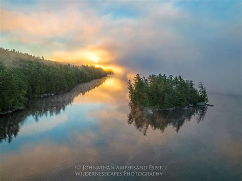 Middle Saranac Lake with rising disc of sun through August fog ...