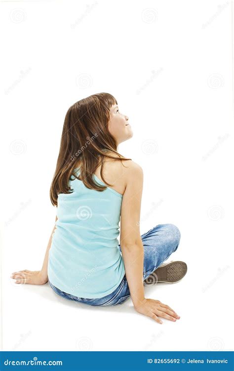Rear View of Little Girl Sitting on Floor, Looking Up Stock Photo ...